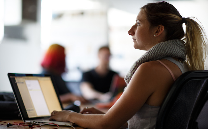 Summer student sitting in class with laptop